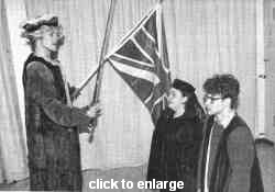 Stefan Enderle schl�gt Ricarda Wagner und Martin Friedrichs zum Ritter. Im Hintergrund die Flagge Gro�britanniens.